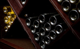 Snapshot of the wine cellar. The bottles on wooden shelves.